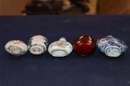 Four 19th century porcelain snuff bottles and an inside painted amber glass snuff bottle